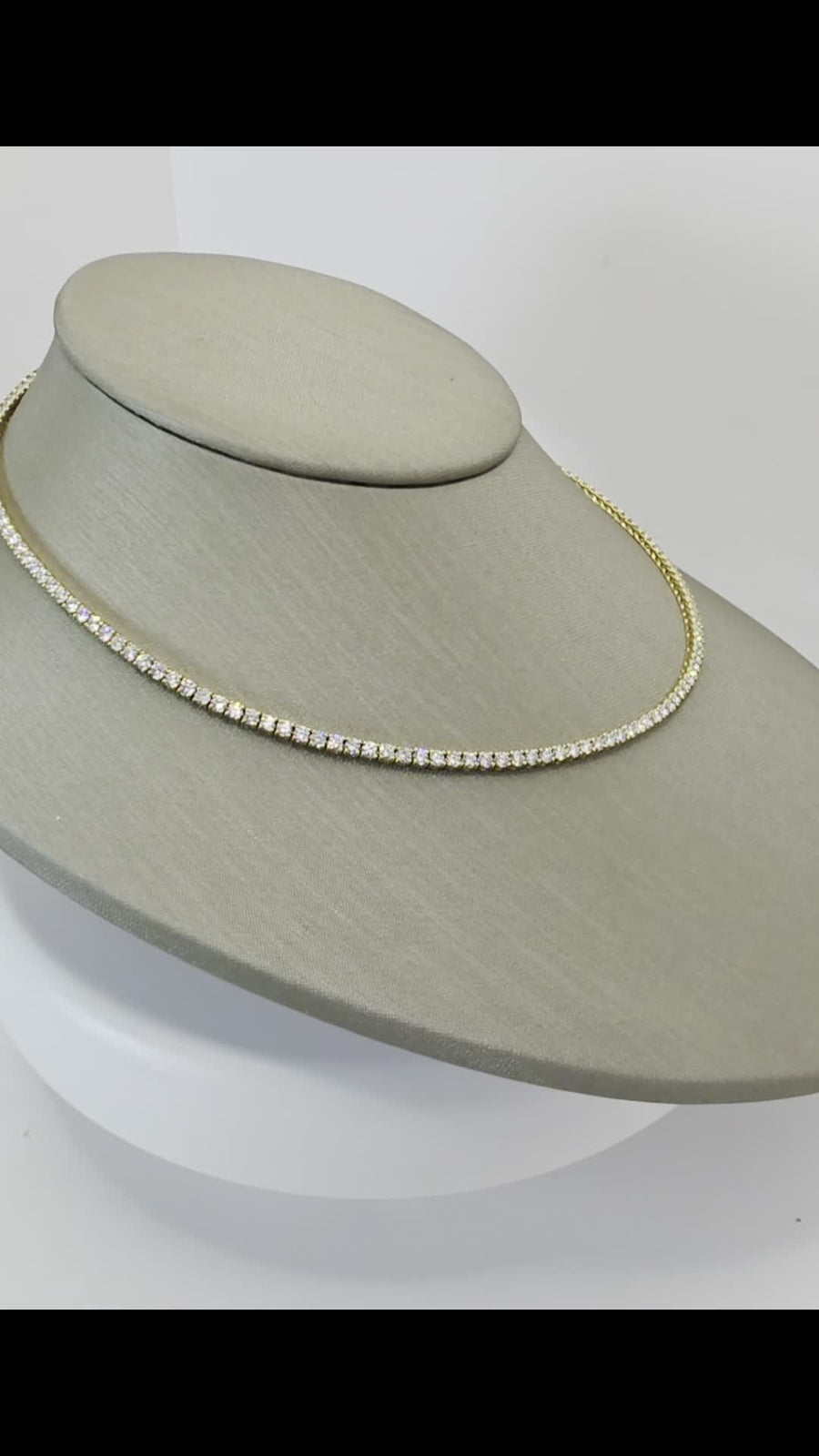 Angled view of an 8 carat lab grown diamond eternity tennis necklace in 14K yellow gold