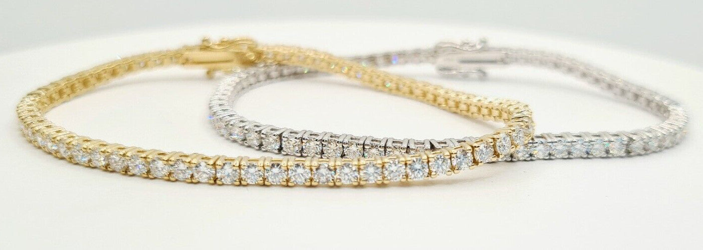 Close up of round brilliant lab grown diamonds set in 14K yellow gold and white gold tennis bracelets