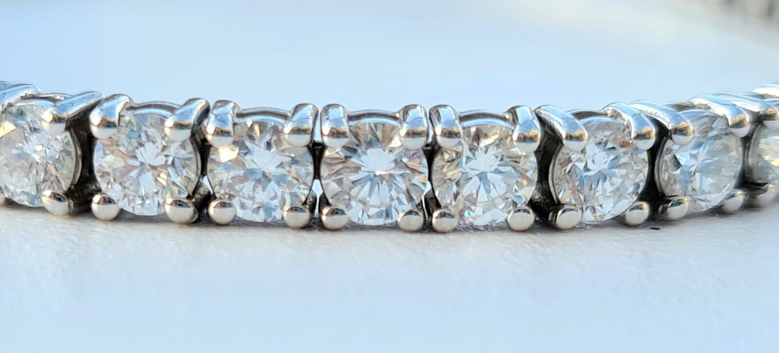 Macro view of four prong set round brilliant lab grown diamonds in a 14K white gold tennis bracelet