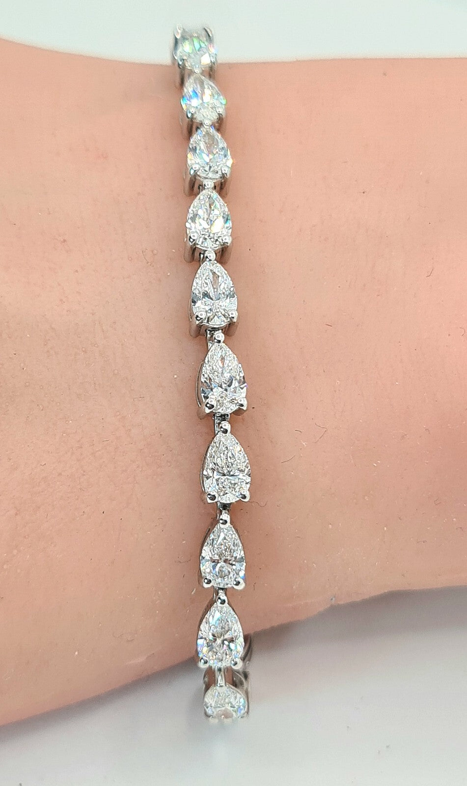 9 carat pear shape lab grown diamond tennis bracelet worn on the wrist in 14K white gold